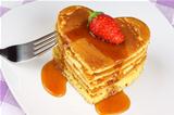 Heart-shaped pancakes with syrup and strawberry