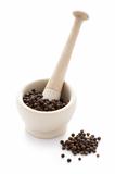 black peppercorns in a white pestle and mortar