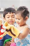 Asian sibling playing hand puppet
