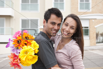 Man surprising his girlfriend with a bouquet