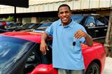 man showing key of new red sports car