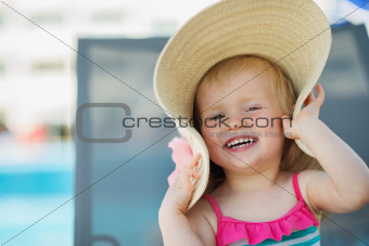 Portrait of laughing baby in beach hat