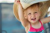 Portrait of excited baby in beach hat
