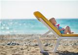 Baby laying on sunbed on beach