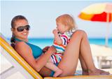 Portrait of happy mother and baby on sun bed