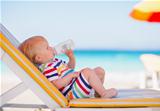 Portrait of baby on sunbed drinking water