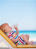 Portrait of baby on sun bed drinking water