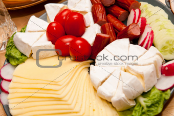 platter of cold cuts cheese and sausages with ham and tomatoes