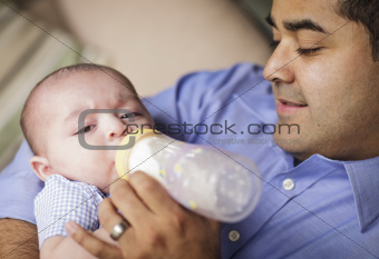 Happy Hispanic Father Bottle Feading His Very Content Son.