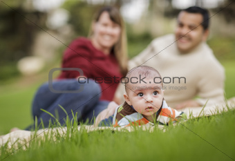 Happy Mixed Race Baby Boy and Parents Playing Outdoors in the Park.