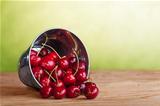 Cherries in a bucket on old wooden table