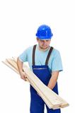 Worker in uniform carrying wooden planks