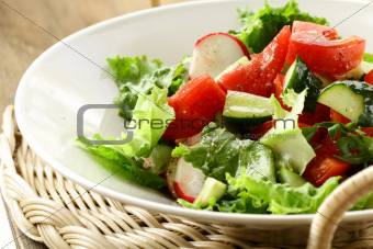 salad with tomato cucumbers and radishes dressed with olive oil