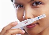 Young woman happily showing pregnancy test
