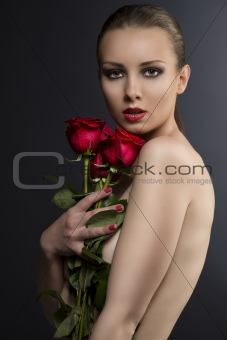 gilr's low key portrait with roses near her face