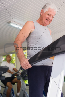 senior man exercising in wellness club