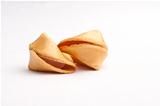 Two unbroken fortune cookies touching against faded white background