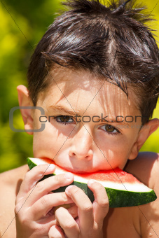 wet boy with watermelon in the garden