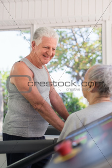 Active senior friends talking and working out in fitness club