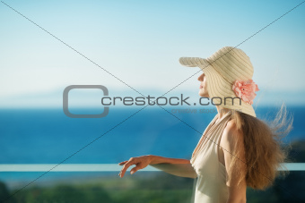 Woman looking on sea from balcony. Rear view