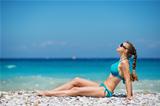 Woman in sunglasses enjoying sunshine on beach