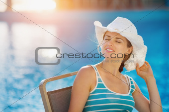 Happy woman sitting at pool bar