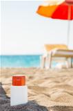Bottle of sun block creme in shadow on beach