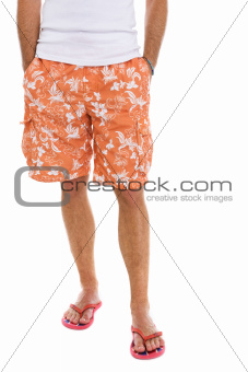Closeup on legs of male in shorts and flip flops