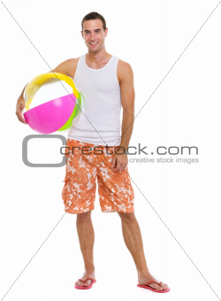 Resting on vacation smiling young man with beach ball