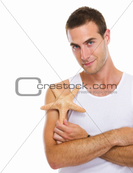Portrait of on vacation young man with sea star