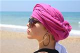 Beautiful woman with pink kerchief, at the beach