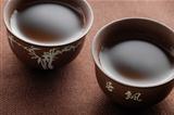 two chinese tea cups on wooden table with tea