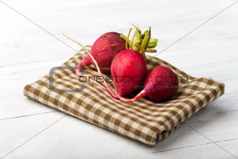 three radishes on wood 