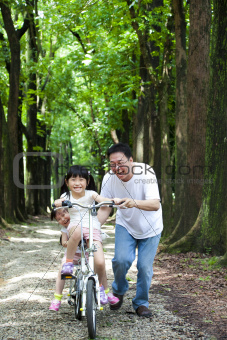 Father Teaching daughter  to riding bicycle