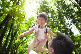 happy little girl with father in the green forest at morning
