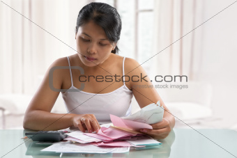 Asian housewife checking all the bills