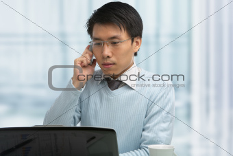 Young Chinese male working in office