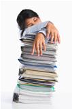 Woman tired behind pile of paper