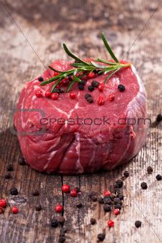 raw steak with pepper on wood 