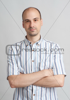 Portrait of a young casual man standing with folded hand