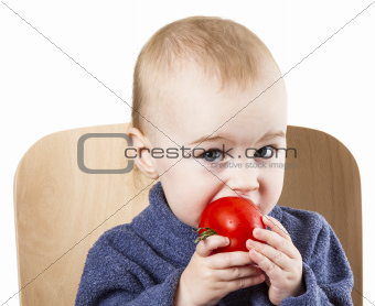young child eating tomatoes in high chair