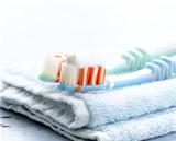 Couple toothbrushes  with toothpaste on a towel