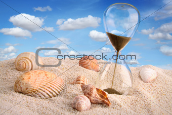Hourglass in the sand with blue sky