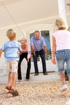Grandparents Welcoming Grandchildren On Visit To Home