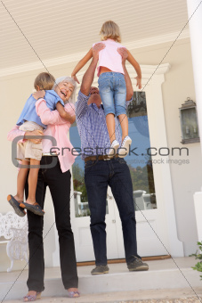 Grandparents Welcoming Grandchildren On Visit To Home