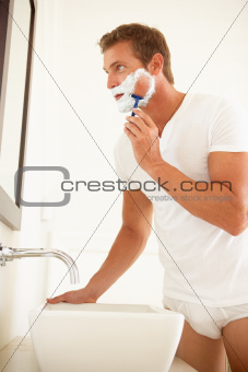 Young Man Shaving In Bathroom Mirror