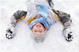 Boy Laying On Ground Making Snow Angel