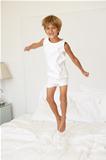 Young Boy Jumping On Bed