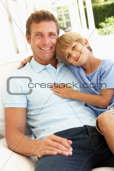 Portrait Of Father And Son Relaxing On Sofa