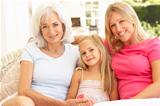 Portrait Of Grandmother, Daughter And Granddaughter Relaxing On Sofa